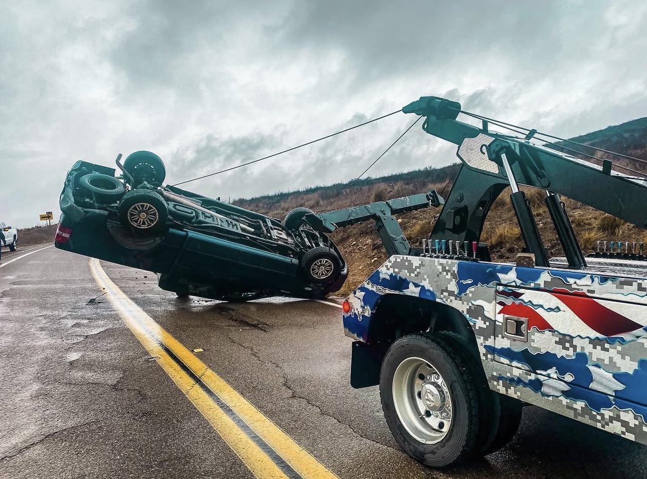 Bulldog Towing recovering an overturned vehicle using heavy-duty recovery equipment on a San Diego highway.